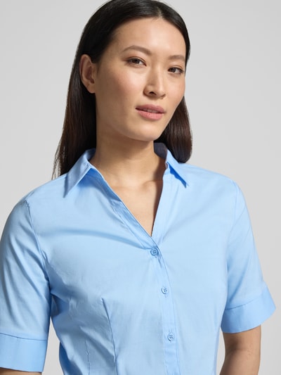 Frauenmodel trägt Hemdbluse im Halbarm-Design von More & More in Hellblau, taillierte Passform, elastischer Baumwoll-Mix, Nahaufnahme Oberkörper.