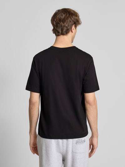 Männermodel trägt T-Shirt mit Label-Stitching Modell 'NORREBRO' von Jack & Jones, schwarz, reine Baumwolle, Ganzkörperansicht Rückansicht