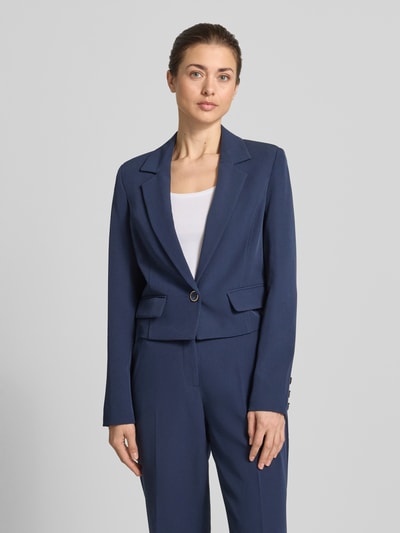Frauenmodel trägt Cropped Blazer mit Reverskragen Modell 'Leila' von Guess aus Elastischer-Material-Mix in Dunkelblau, Pattentaschen, Knopfverschluss, Cropped-Fit, Ganzkörperansicht von vorne. Rückenlänge bei Größe S: 47 cm, Brustweite: 42 cm, Ärmellänge: 64 cm.