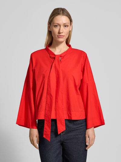 Modelka nosi bluzkę 'Bluse mit Schluppe und stark überschnittenen Schultern' z bawełny od comma, luźny krój, czerwona, długość tyłu 56 cm, długość rękawów 54 cm, widok całej sylwetki z przodu.