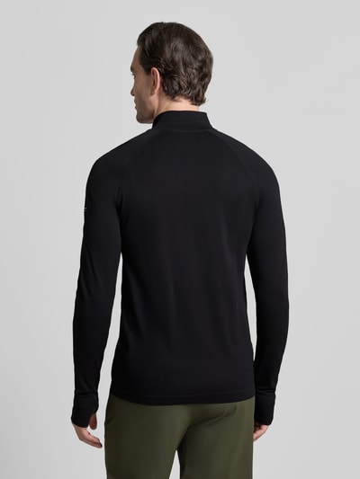 Männermodel trägt Slim Fit Longsleeve mit Logo-Print von Fabletics, schwarzer Troyer-Kragen, glatte Textur, Rückansicht Ganzkörperansicht.