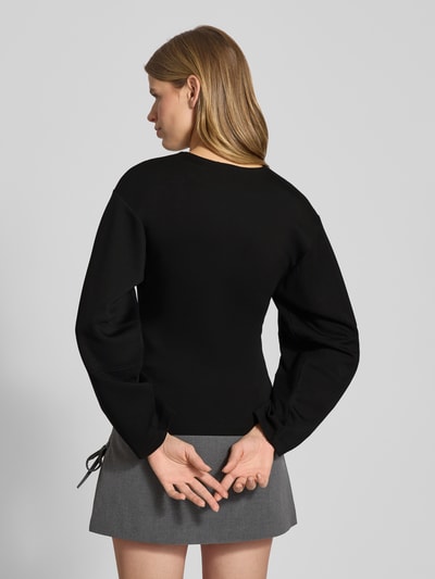 Frauenmodel trägt Shaped Fit Langarmshirt mit Viskose-Anteil Modell 'TOC' von Only, unifarben, Ziernähte, Sweatmaterial, Ganzkörperansicht Rückansicht.