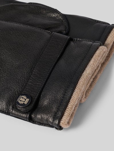 Produktfoto, Lederhandschuhe aus echtem Leder Modell 'Wilhelmshaven' von Roeckl, schwarzes Leder, Riegel mit Label-Detail, Strukturmuster, elastisches Rippbündchen, Kontrast aus Schwarz und Beige, Detailaufnahme