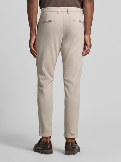 Männermodel trägt Slim Fit Stoffhose mit umgeschlagenen Hosenbeinen von Lindbergh, Beige, elastisch, Rückansicht, Ganzkörperansicht. Elastischer Material-Mix mit Viskose-Anteil, Gürtelschlaufen, Knopf- und Reißverschluss, Bundweite bei Größe M 43 cm, Innenbeinlänge 73 cm.