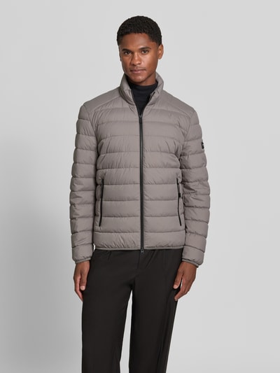 Männermodel trägt Regular Fit Steppjacke mit Zweiwege-Reißverschluss von Marc O'Polo, grau, glatte Oberfläche, Ganzkörperansicht von vorne.