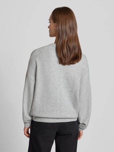 Vrouwenmodel draagt Regular Fit Pullover in tricotlook van review, materiaalmix met stretch, ribboorden, lange mouw, ruglengte maat S 59 cm, mouwlengte 52 cm, geheel in lichtgrijs, grof gebreide structuur, recht model, geribde bies, rugaanzicht.