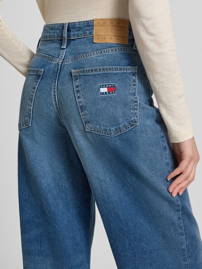 Vrouwenmodel draagt Wide Leg Jeans aus Baumwoll-Mix van Tommy Jeans in uni blauw denim met high waist, label patch en logo-detail, detailopname rug.