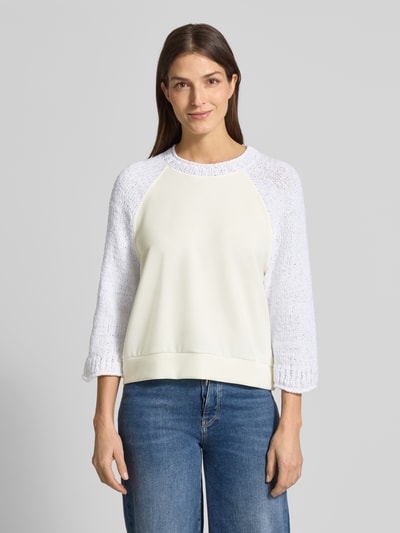 Frauenmodel trägt Relaxed Fit Pullover mit Strick-Besatz von Marc Cain im Baumwoll-Mix, Rundhalsausschnitt, cremeweiß und weiß, Nahaufnahme Oberkörper.