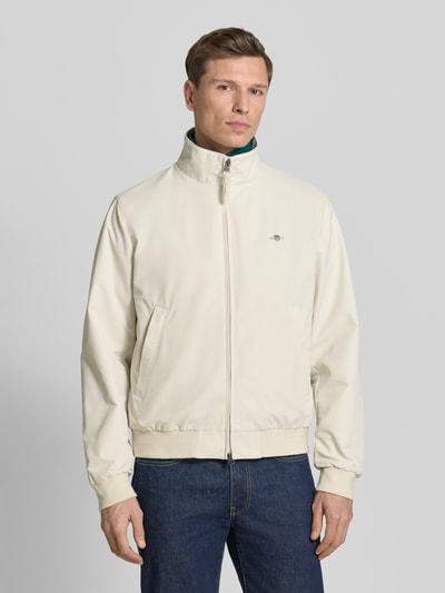 Männermodel trägt Jacke mit Stehkragen und Zweiwege-Reißverschluss von Gant im Material-Mix mit Baumwoll-Anteil, Regular-Fit, Eingrifftaschen, Label-Stitching, Farbe Creme, Ganzkörperansicht von vorne.
