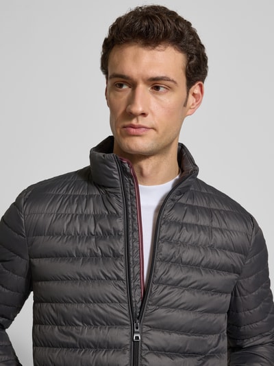 Männermodel trägt Steppjacke mit Stehkragen und Zweiwege-Reißverschluss von Geox in Anthrazit, regelmäßig geschnitten, Nahaufnahme Oberkörper.