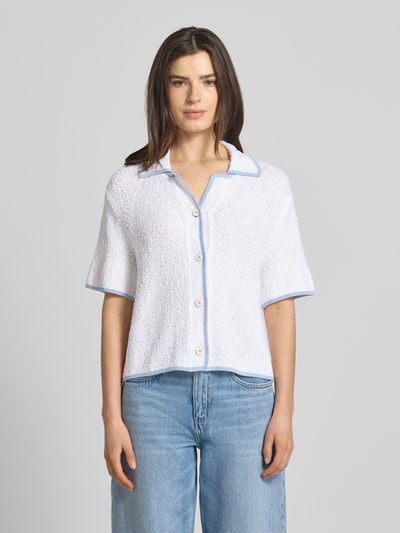 Frauenmodel trägt Strickjacke mit Viskose-Anteil von Marc Cain, weiß mit blauen Akzenten, strukturierte Oberfläche, gerader Schnitt, Umlegekragen, Knopfleiste, 1/2-Arm, Baumwoll-Mix, Ganzkörperansicht von vorne.