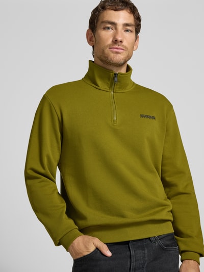 Männermodel trägt Relaxed Fit Sweatshirt aus elastischem Baumwoll-Mix von Napapijri, Troyer-Kragen, Label-Detail, Nahaufnahme Oberkörper.