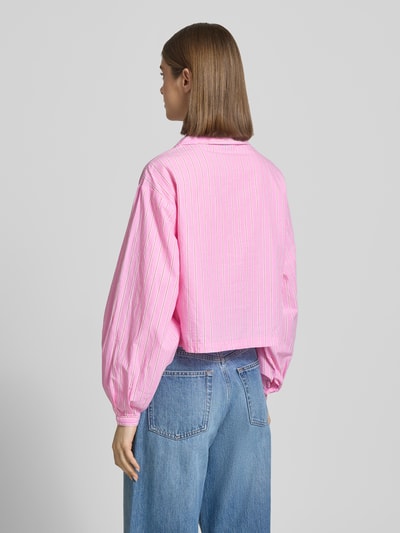Frauenmodel trägt Relaxed Fit Pyjama-Oberteil mit Brusttasche von Gina Tricot, rosa mit weißen Streifen aus reiner Baumwolle, Ganzkörperansicht Rückansicht.