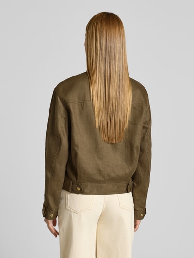 Frauenmodel trägt Relaxed Fit Utility-Jacke aus reinem Leinen von Tommy Hilfiger in Oliv, Pattentaschen, Stehkragen, Ganzkörperansicht Rückansicht.