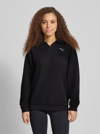 Frauenmodel trägt Relaxed Fit Poloshirt mit Lyocell-Anteil von PUMA, Schwarz, Elastischer-Material-Mix, Logo-Detail, Polo-Kragen, Langärmelig, elastische Abschlüsse, Ganzkörperansicht von vorne.