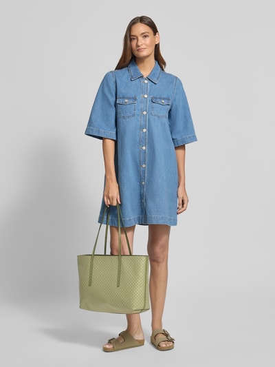 Frauenmodel trägt Shopper mit Logo-Muster von CK Calvin Klein, grün, strukturierte Oberfläche, Tragehenkel, herausnehmbare Pouch, Ganzkörperansicht von vorne.