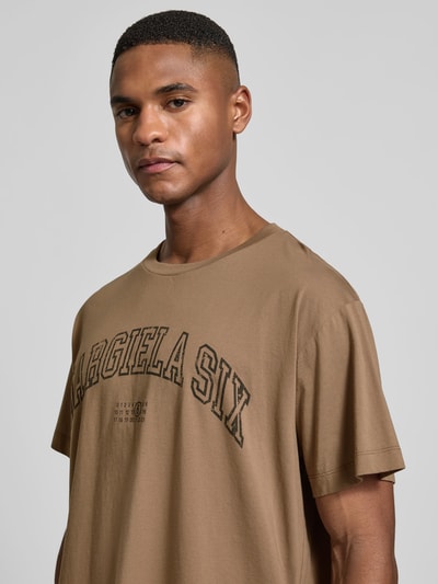 Männermodel trägt Regular Fit T-Shirt mit Logo-Print von MM6 Maison Margiela, Reine Baumwolle, Statement-Print, Rundhalsausschnitt, Nahaufnahme Oberkörper.