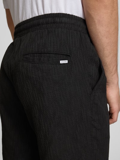 Männermodel trägt Shorts mit Strukturmuster Modell 'JAIDEN' von Jack & Jones, Schwarz, Material-Mix, Regular-Fit, Detailaufnahme Rückansicht.