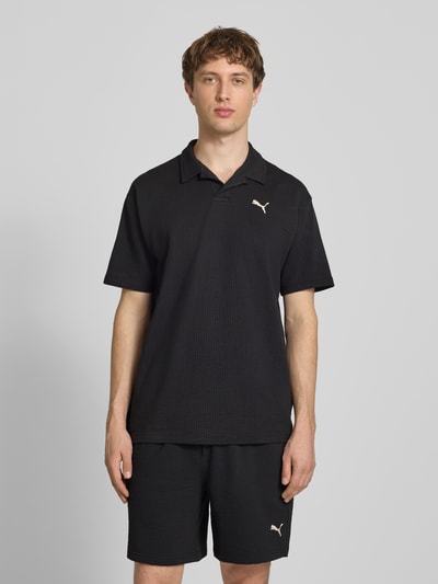 Männermodel trägt Regular Fit T-Shirt mit Logo-Stitching von PUMA PERFORMANCE, Baumwoll-Mix mit Stretch-Anteil, Strukturmuster, Ganzkörperansicht von vorne.