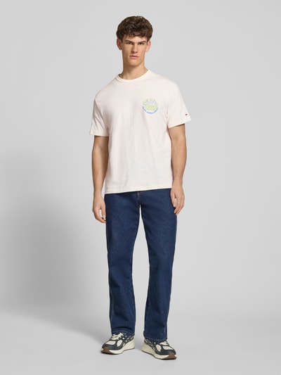 Männermodel trägt Relaxed Fit T-Shirt aus reiner Baumwolle von Tommy Jeans, Optik: Unifarben, Passform: Relaxed-Fit, Label-Print, Rundhals, Ärmelform: Kurzarm, Materialverarbeitung: Jersey, Ganzkörperansicht von vorne.