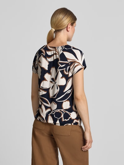 Frauenmodel trägt Regular Fit T-Shirt aus Viskose-Mix von Betty Barclay mit floralem Muster in Creme und Dunkelblau, Ganzkörperansicht Rückansicht.