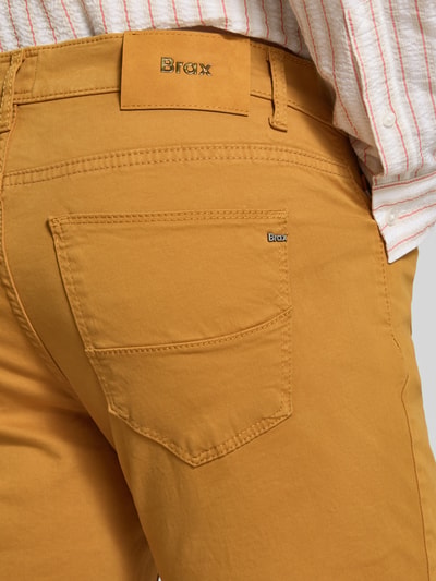 Männermodel trägt Stoffhose aus Baumwoll-Mix mit Viskose-Anteil Modell 'Cadiz' von Brax in Ocker, strukturierte Oberfläche, Nahaufnahme Rückansicht, Herren Stoffhose von Brax.
