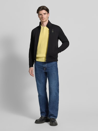 Männermodel trägt schwarze Sweatjacke mit Stehkragen Modell 'City New' von Blauer Usa aus Baumwoll-Mix, Slim-Fit, Ganzkörperansicht von vorne.