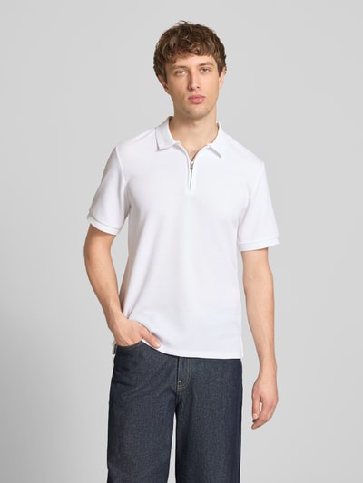 Männermodel trägt Regular Fit Poloshirt mit Reißverschluss Modell 'AUSTIN' von Jack & Jones, weiß, Strukturmuster, Ganzkörperansicht von vorne.