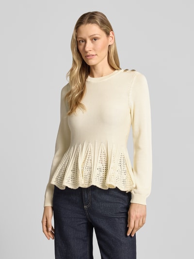 Modelka kobieca nosi Strickshirt mit Schößchen Modell 'UTAMA' od Bash z mieszanki bawełny i modalu, dopasowany krój, okrągły dekolt, ozdobne guziki, baskinka z perforowaniem, prążkowane zakończenia rękawów, długość tyłu w rozmiarze S: 58 cm, długość rękawów w rozmiarze S: 63 cm, kolor kremowy, faktura gładka i ażurowa, widok całej sylwetki z przodu.