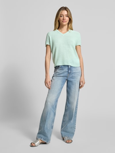 Frauenmodel trägt T-Shirt in Strick-Optik mit V-Ausschnitt von Rich & Royal in Mint, Baumwoll-Mix, Straight Fit, Rückenlänge 40 cm, Ganzkörperansicht von vorne.