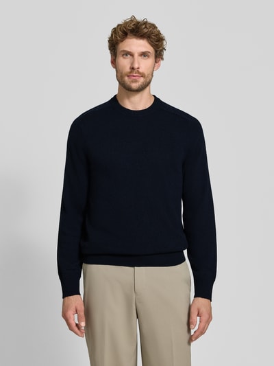 Männermodel trägt Regular Fit Strickpullover aus reinem Kaschmir von FTC Cashmere in Dunkelblau, Stehkragen, gerippte Abschlüsse, Ganzkörperansicht von vorne.
