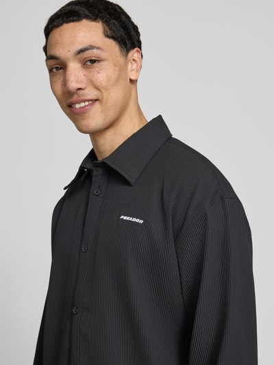 Mężczyznamodel nosi Regular Fit Freizeithemd mit Kentkragen und Label-Stitching od Pegador, czarny materiał z fakturą, krój regular fit z domieszką stretchu, model 'Troy', Szerokość w rozmiarze M: 50 cm, długość tyłu: 68 cm, długość rękawa: 60 cm, widok z przodu, zbliżenie na górną część ciała.