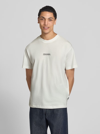 Männermodel trägt T-Shirt mit Label-Print von Replay, weiß, reine Baumwolle, gerader Schnitt, Rundhalsausschnitt, Ganzkörperansicht von vorne.