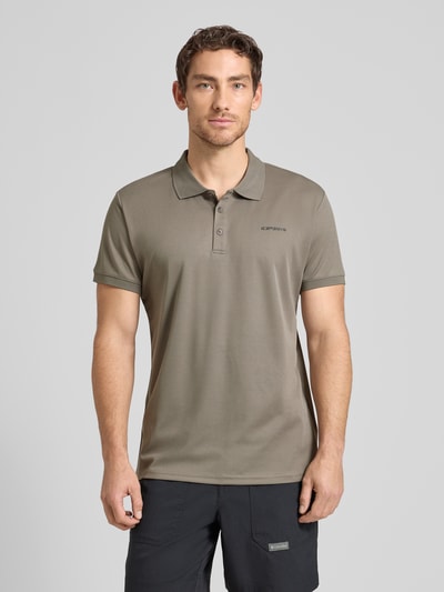 Męski model nosi koszulkę polo Regular Fit Poloshirt mit Logo-Print Modell 'BELLMONT' od Icepeak, krój regular fit, kołnierzyk polo, z krótkim rękawem, nadruk z logo, długość tyłu w rozmiarze M: 73 cm, kolor oliwkowy, gładka faktura, widok całej sylwetki z przodu.