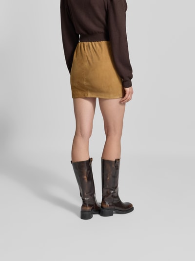 Frauenmodel trägt Minirock aus echtem Ziegenvelours von ROTATE in Camel, Regular Fit, Falten-Optik, Rückansicht Ganzkörperansicht