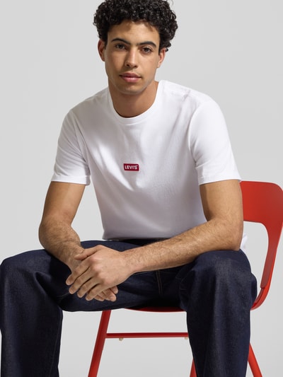 Männermodel trägt T-Shirt mit Label-Detail von Levi's®, reine Baumwolle, Relaxed-Fit, gerippter Rundhalsausschnitt, Nahaufnahme Oberkörper.