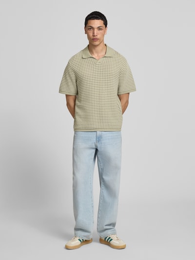 Männermodel trägt Regular Fit Poloshirt mit V-Ausschnitt von Jack & Jones, Strickshirt, Reine Baumwolle, beige kariert, Ganzkörperansicht von vorne.