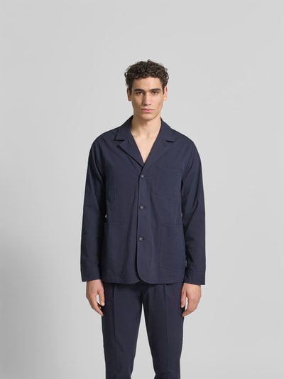 Männermodel trägt Relaxed Fit Hemdjacke aus Baumwolle von Officine Générale in Dunkelblau, aufgesetzte Eingriff- und Brusttasche, Reverskragen, Knopfleiste, reine Baumwolle, Ganzkörperansicht von vorne.