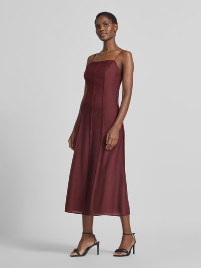 Frauenmodel trägt bordeauxfarbenes, tailliertes Freizeitkleid aus Lyocell-Mix mit Woll-Anteil Modell 'D076-WaistSlipDr' von Jake*s Collection, glatte Textur, Ganzkörperansicht von vorne.