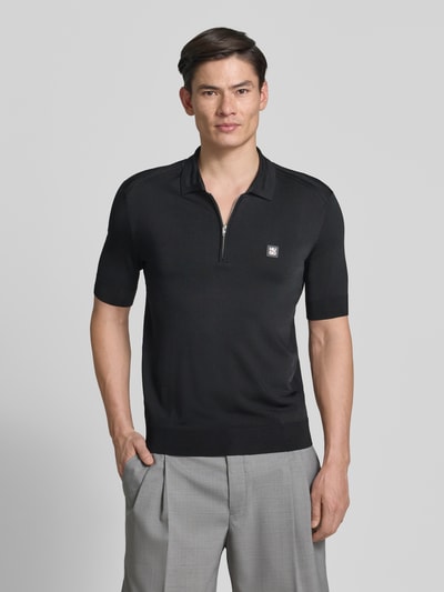 Männermodel trägt Regular Fit Poloshirt aus Viskose-Mix Modell 'SAYFONG-4' von HUGO, Farbe Schwarz, Optik: Unifarben, Label-Patch, Kragenform: Polokragen, Knopfleiste, kurzarm, Ärmelabschluss und Rumpfabschluss: gerippt, Materialverarbeitung: Jersey, Ganzkörperansicht von vorne.