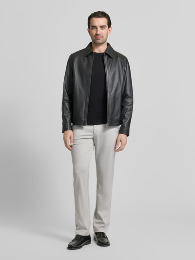 Męski model nosi Regular Fit Stoffhose mit französischen Eingrifftaschen von Christian Berg Men, mieszanka materiałów z dodatkiem wiskozy, prosty krój, jasnoszary kolor, wpuszczane kieszenie, zapięcie na guzik i zamek błyskawiczny, kieszenie z tyłu, szerokość w rozmiarze 50: 44 cm, długość wewnętrzna nogawki w rozmiarze 50: 81 cm, widok całej sylwetki z przodu.