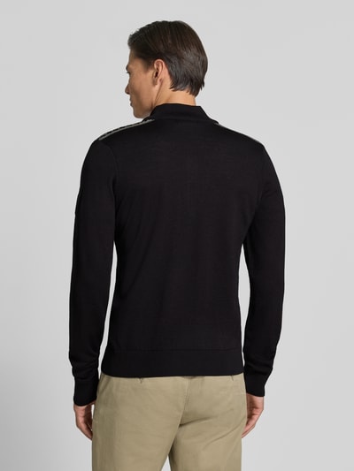 Männermodel trägt Wollpullover mit Label-Patch Modell 'Liaset' von Dale of Norway in Schwarz, gerade Form, Rückansicht, reine Wolle.