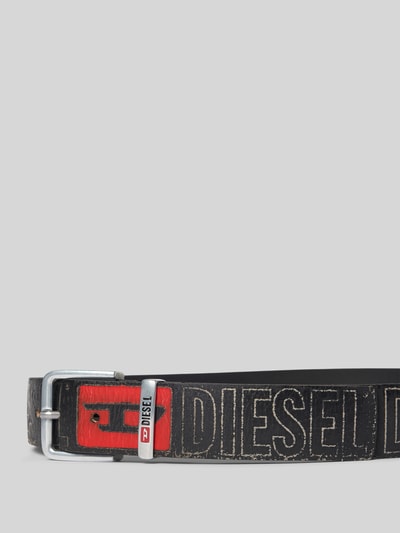 Produktfoto, Ledergürtel aus echtem Leder von Diesel für Herren, Rindsleder im Used-Look, schwarze Farbe, Metall-Dornschließe, Label-Prints, breite Passform, 4 cm bei Größe 90, rote Akzente, leichte Struktur im Leder.