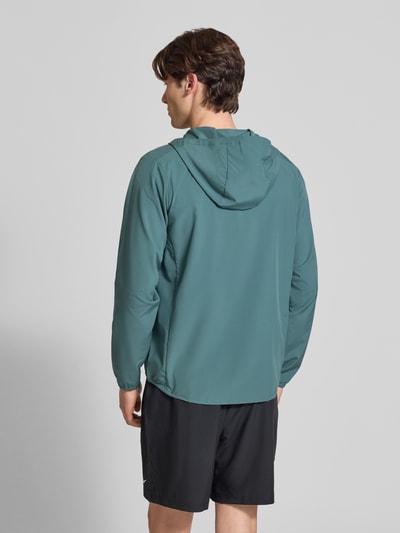Männermodel trägt Trainingsjacke mit Logo-Print und Stehkragen von NIKE TRAINING in Grün, elastische Ärmelabschlüsse, seitliche Eingrifftaschen, Reißverschluss, gerader Schnitt, Rückenlänge 69 cm, Ärmellänge 65 cm, Ganzkörperansicht Rückansicht.