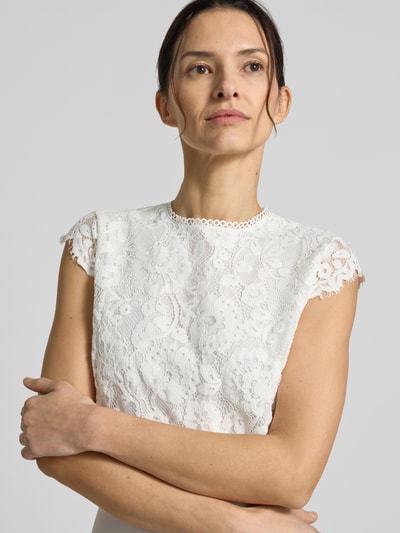 Frauenmodel trägt Brautkleid in Midilänge Modell 'Lilia' von GUIDO MARIA KRETSCHMER WOMAN mit Spitze am Oberteil, Nahaufnahme Oberkörper.