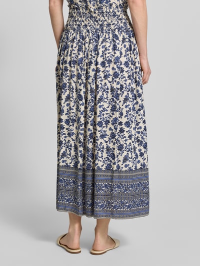 Frauenmodel trägt Maxirock aus Viskose im Allover-Look Modell 'Myra' von LOLLYS LAUNDRY, blau-weißes florales Muster, A-Linie, Ganzkörperansicht Rückansicht