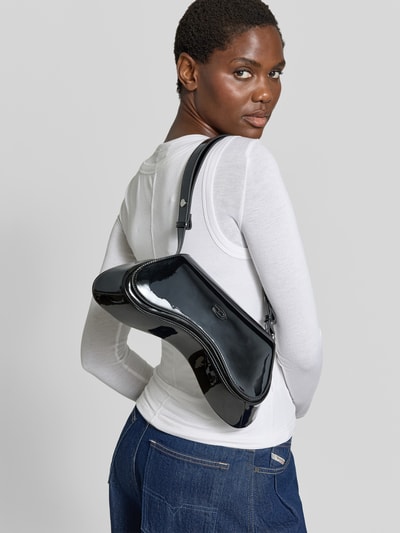Frauenmodel trägt schwarze Schultertasche mit Logo-Detail von Diesel, glänzende Oberfläche, rechteckige Form, Nahaufnahme Oberkörper. Damen Schultertasche von Diesel, Hauptfach mit Überschlag, verstellbarer Schulterriemen, Maße: 22x15x8 cm.