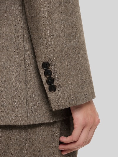 Frauenmodel trägt Slim Fit Longblazer aus Viskose-Mix Modell 'Jonahsa' von BOSS in meliertem Braunton mit feiner Struktur, Nahaufnahme Unterarm. Damen Longblazer von BOSS.