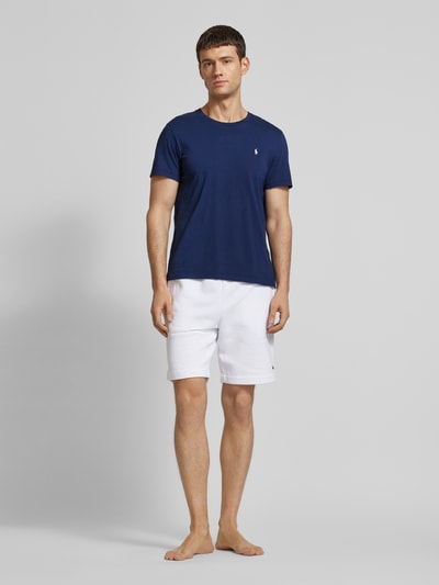 Męski model nosi T-Shirt z logo-stitching od Polo Ralph Lauren, granatowa bawełna, prosty krój, okrągły dekolt, widok całej sylwetki z przodu.