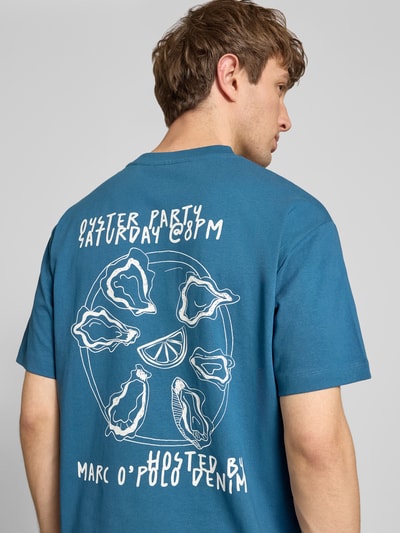 Männermodel trägt Relaxed Fit T-Shirt aus reiner Baumwolle mit Motiv-Print von Marc O'Polo Denim in Optik: Unifarben, Ganzkörperansicht Rückansicht.